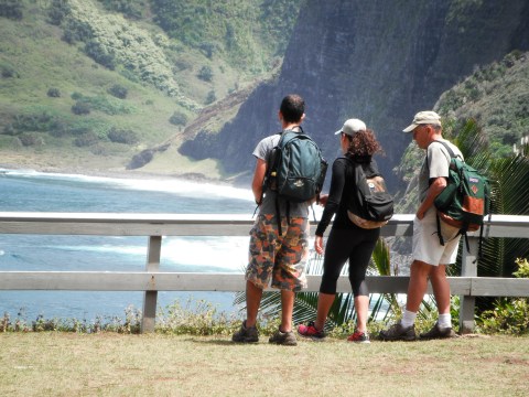 a group of people standing around a bench with a mountain in the background