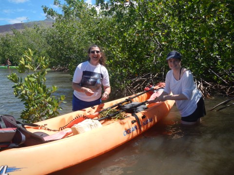 a person standing beside a kayak