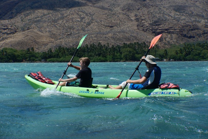 a man flying a kite in a boat on the water