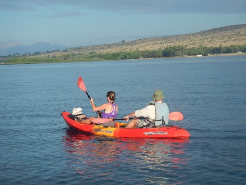 a man riding on the back of a boat in a body of water