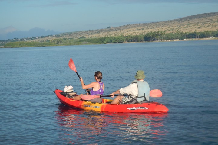 a man riding on the back of a boat in a body of water