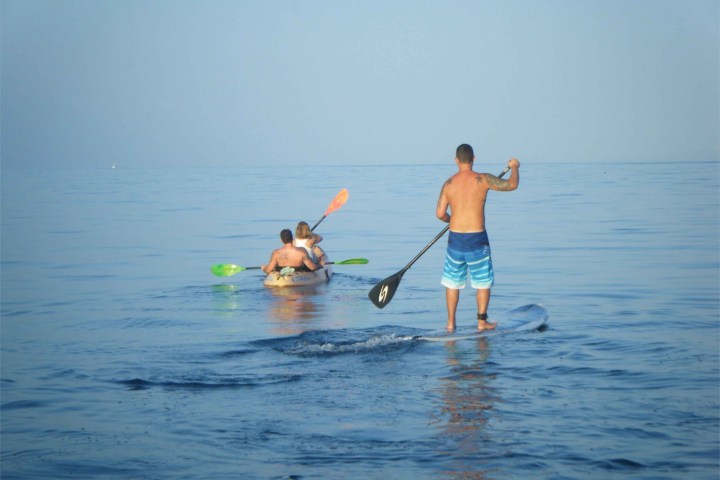a group of people rowing a boat in the water